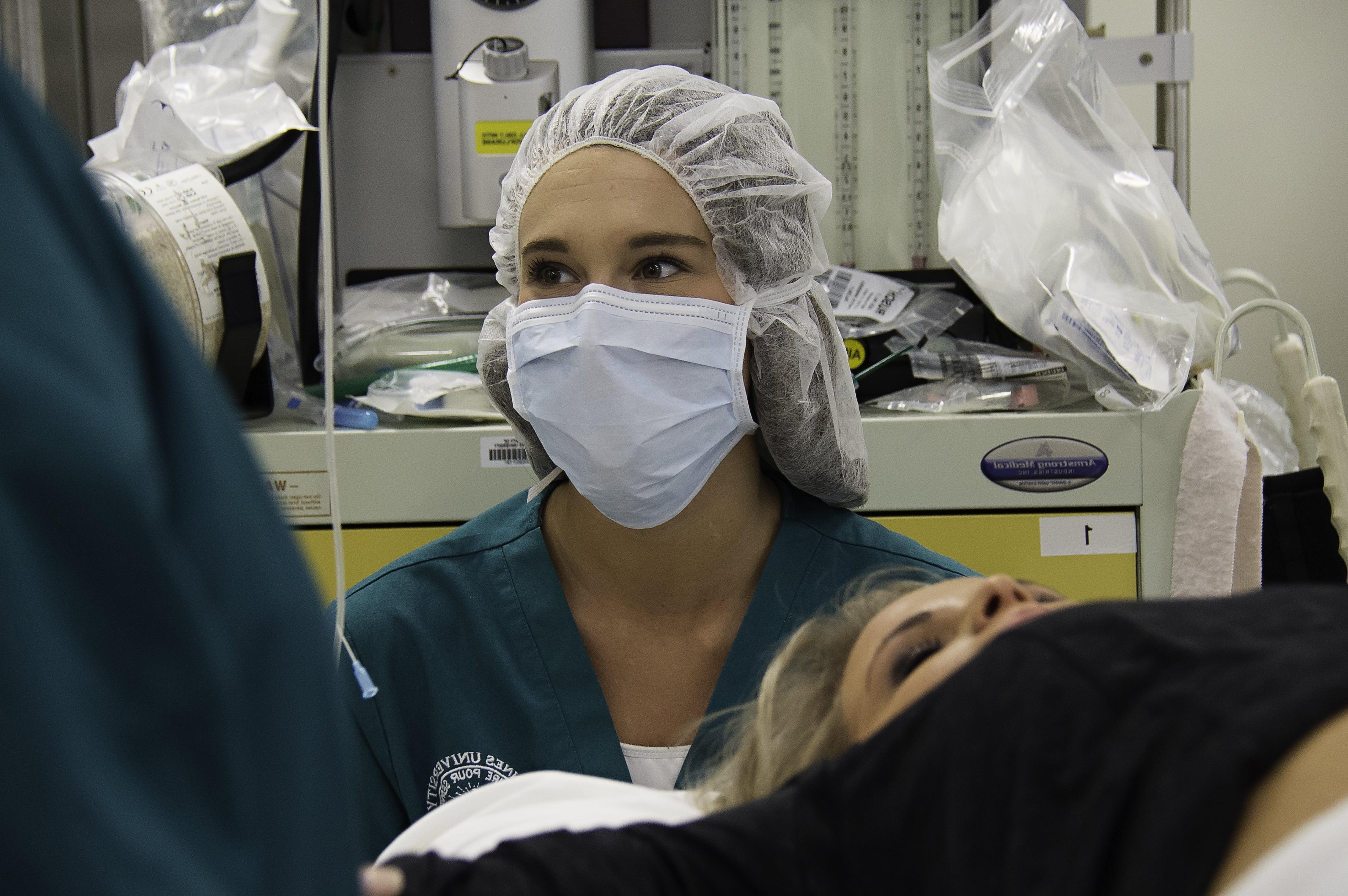 Surgical tech student watching instructor.