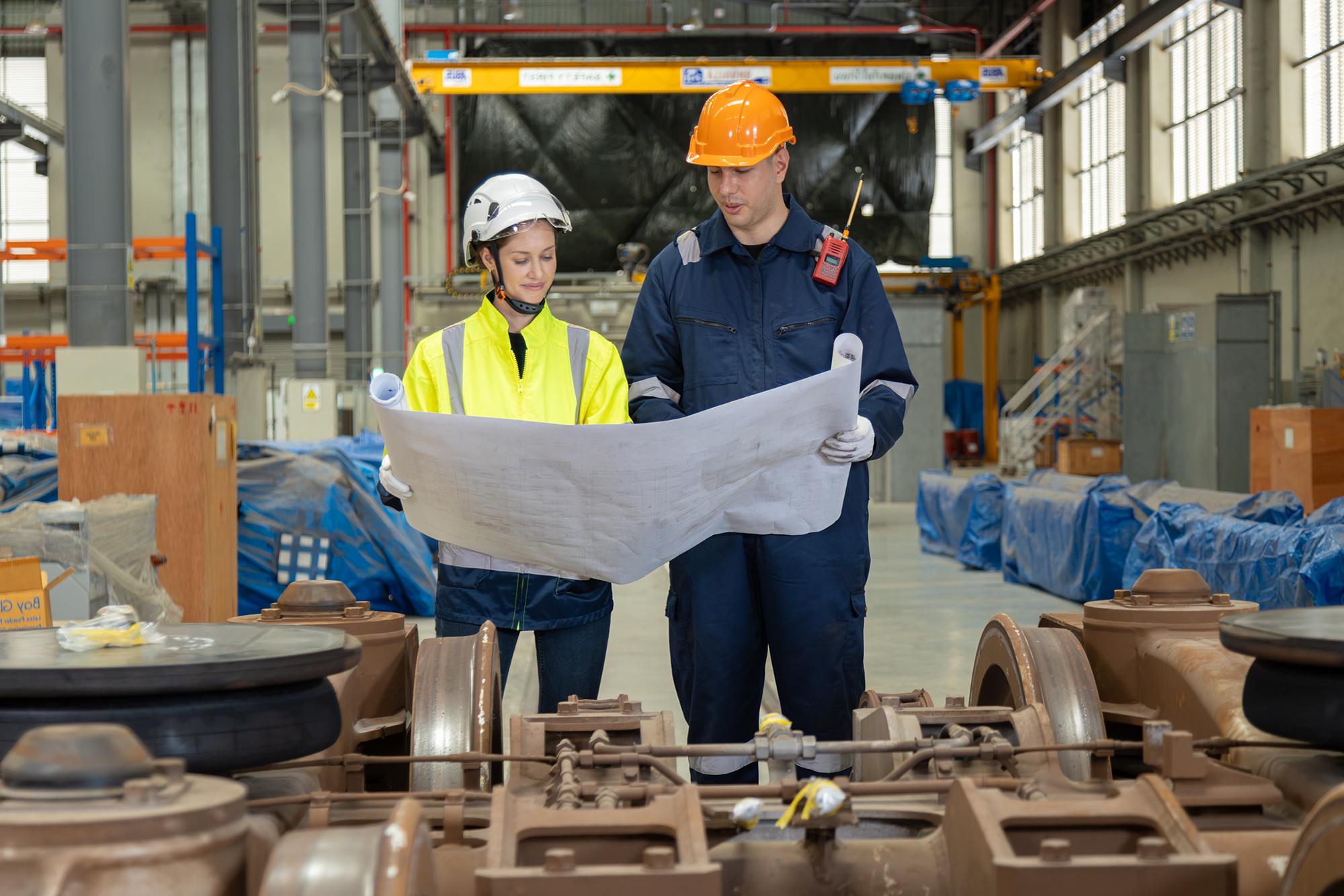 Engineers checking blueprints for directions.